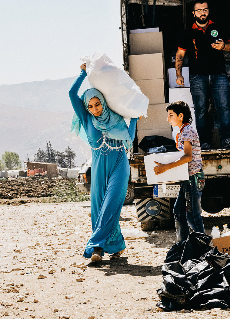 Woman carrying emergency relief supplies in Lebanon